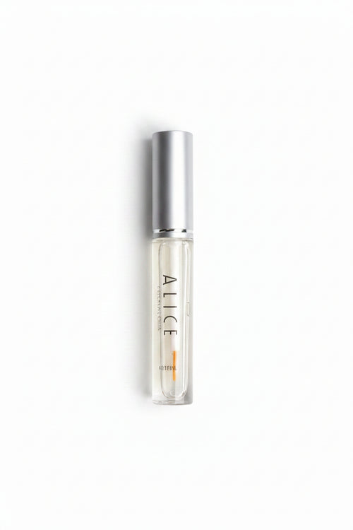 Small clear rollerball bottle with silver top on a gray background